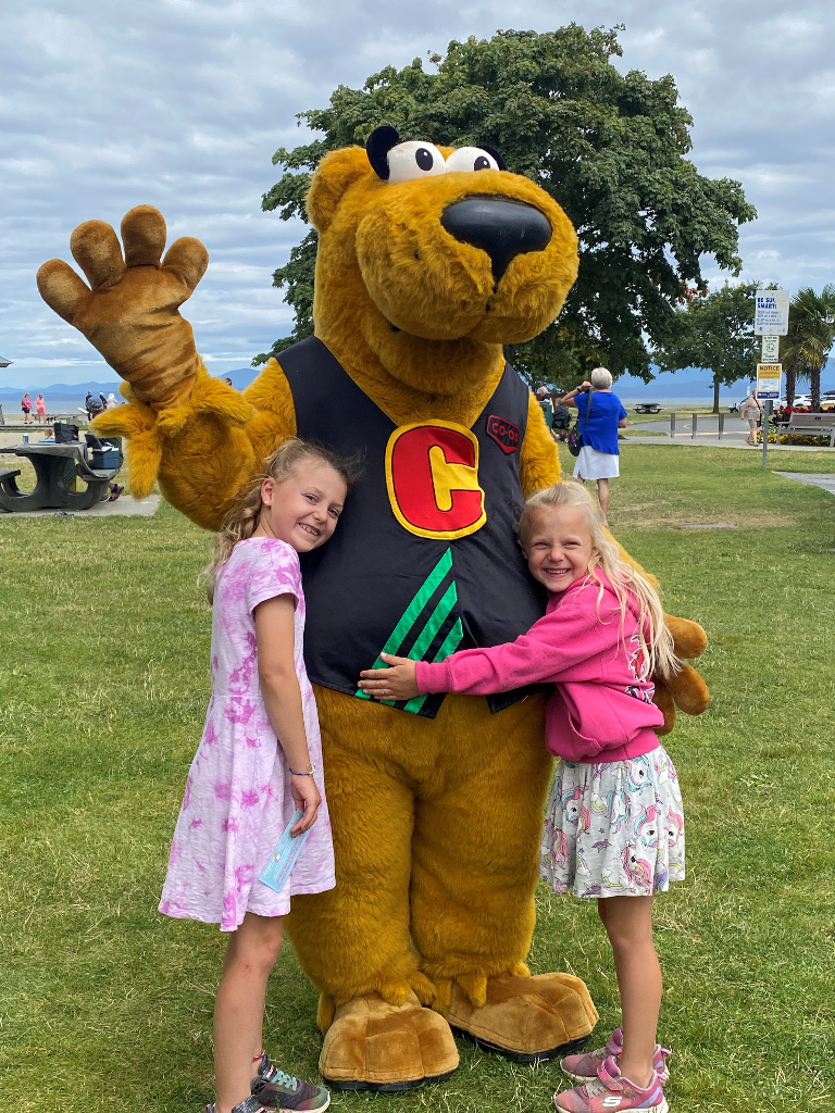 Co-op mascot Cooper being hugged by children