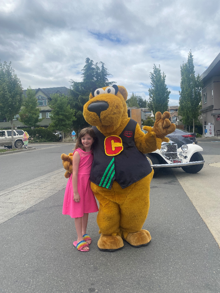 Co-op mascot Cooper with a smiling child